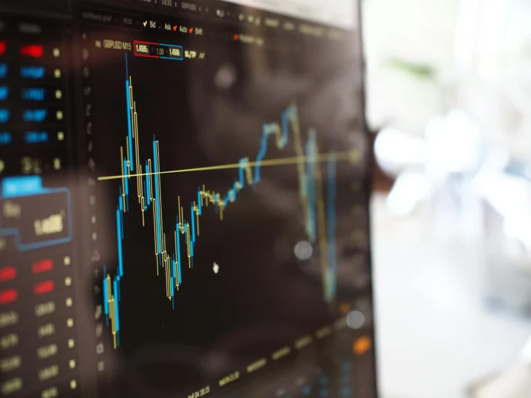 Tela de computador exibindo gráfico de análise financeira com linhas de candlestick e indicadores de mercado, representando dados de variação de preços em tempo real.